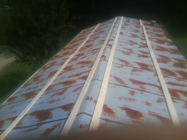 Rusted metal roof panels with new wood purlins before replacement — Storm Damage Roof Repair in Erskine by Roofing Brothers