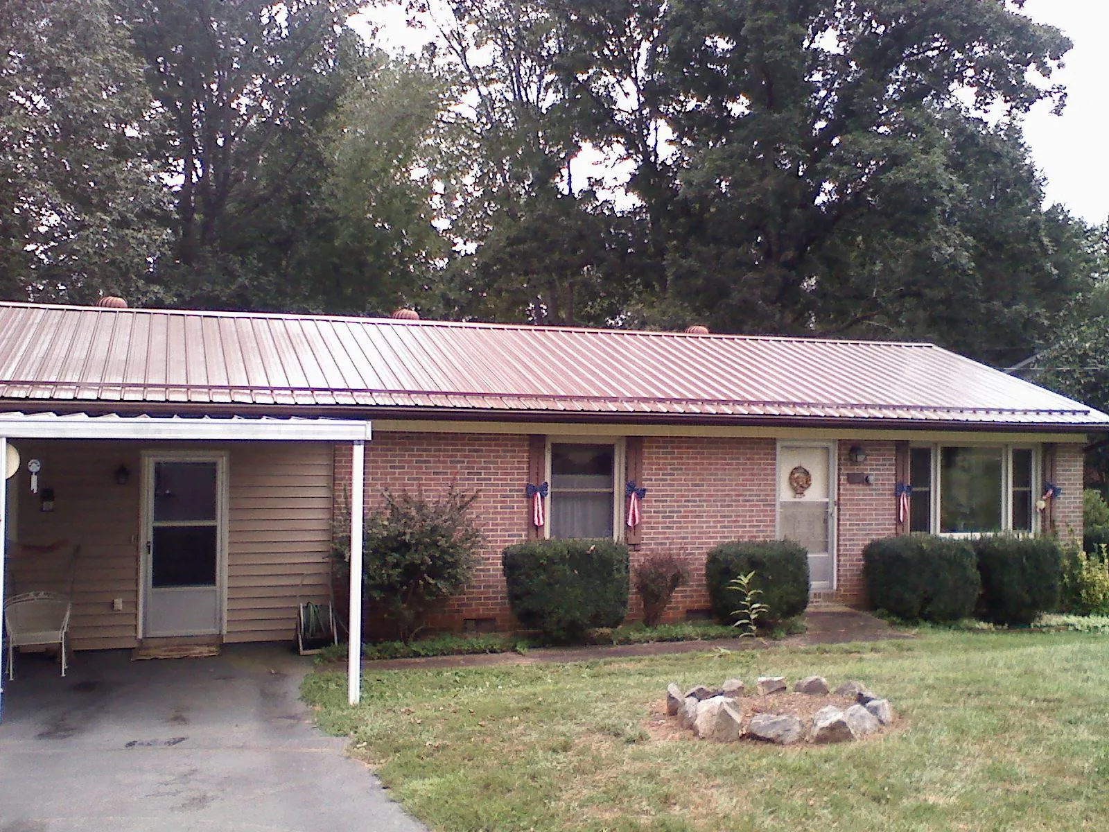 Bronze metal roof and carport on a brick ranch home — Roof Repair work by our crew in Erskine